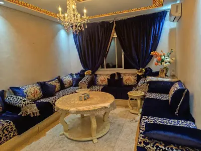 a living room with a blue couch and a table at Appartement a Oulad Mtaa ,Prés du stade Moulay Abdallah,Rabat in Rabat