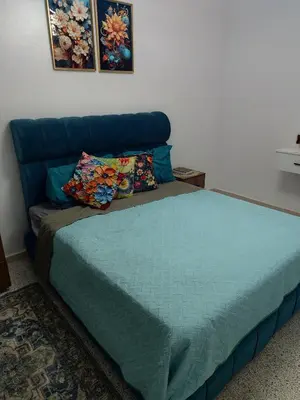 a bedroom with a bed and a blue couch at Appartement a Oulad Mtaa ,Prés du stade Moulay Abdallah,Rabat in Rabat