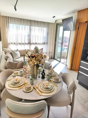 a living room with a table and chairs at Studio luxueux CFC in Casablanca