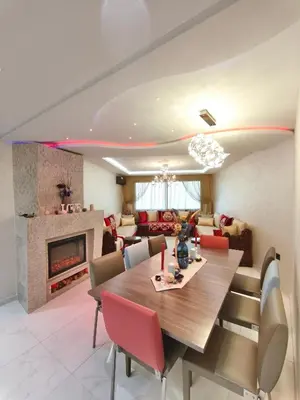 a living room with a dining table and a fireplace at Luxueuse appartement centre ville TGV in Casablanca