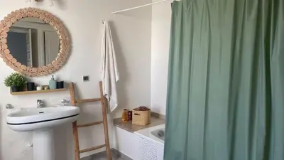 a bathroom with a green shower curtain and a sink at Entire villa with sea view - Bouznika Plage David in Bouznika