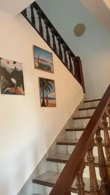 a staircase with some pictures on the wall at Entire villa with sea view - Bouznika Plage David in Bouznika