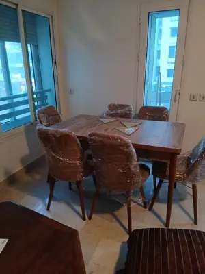a wooden dining room table with chairs and windows at BK anfa in Casablanca