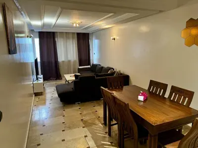 a living room with a table and a couch at Charming Family Appartment in Rabat