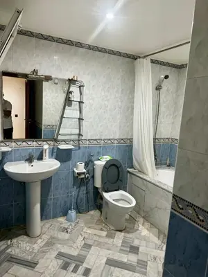 a bathroom with a toilet and a sink and a tub at Charming Family Appartment in Rabat