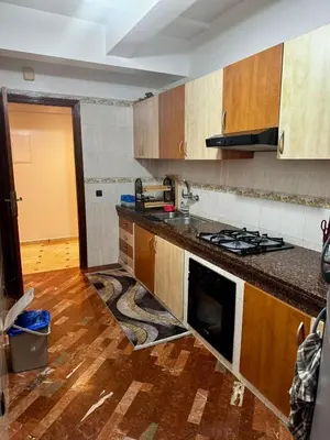 a kitchen with wooden cabinets and a stove top oven at Charming Family Appartment in Rabat