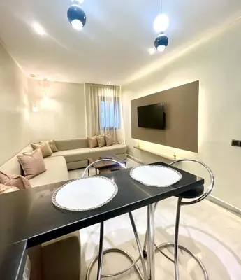 a living room with a table and a couch at Stay Here In Casablanca Center in Oulad Akkou