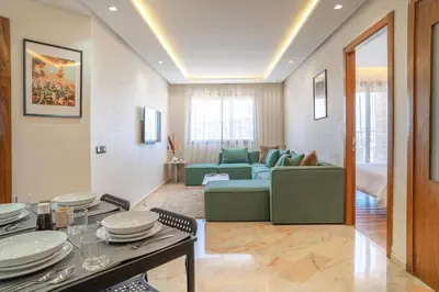 a living room with a green couch and a table at Appartement luxueux &chaleureux Agdal rabat in Rabat