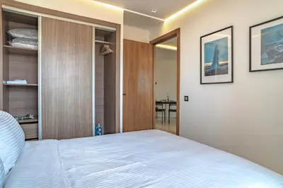 a bedroom with a white bed and a table at Appartement luxueux &chaleureux Agdal rabat in Rabat