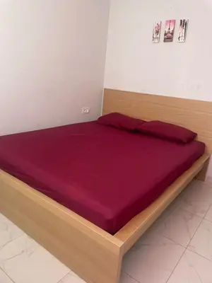 a bed with a wooden frame in a room at Résidence Picasso in Casablanca