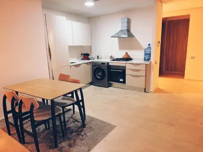 a kitchen and dining room with a table and a stove at Ain Diab , Luxury El amri in Casablanca