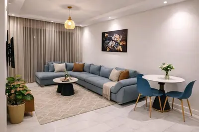 a living room with a blue couch and two tables at EDEN Palmier in Casablanca