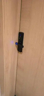 a black object is attached to a wooden door at EDEN Palmier in Casablanca