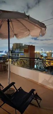 a chair and an umbrella on a balcony at Private Room in Shared Apartment step by mosquée Hassan II in Casablanca