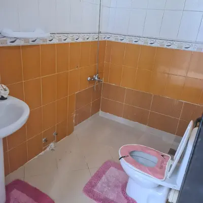a bathroom with a pink toilet and a sink at Private Room in Shared Apartment step by mosquée Hassan II in Casablanca