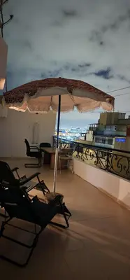 a patio with an umbrella and a table and chairs at Private Room in Shared Apartment step by mosquée Hassan II in Casablanca