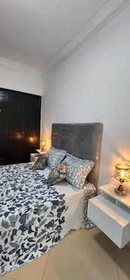 a bedroom with a bed with a black and white comforter at Private Room in Shared Apartment step by mosquée Hassan II in Casablanca