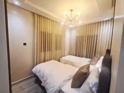 a bedroom with two beds and a mirror at Large luxurious apartment opposite to Hassan 2 Mosqu and FAIR international casablanca , near downtown prohibited arb unmarried couples, Free underground parking for buildings, 3 rooms, 2 bathroom, living room in Casablanca