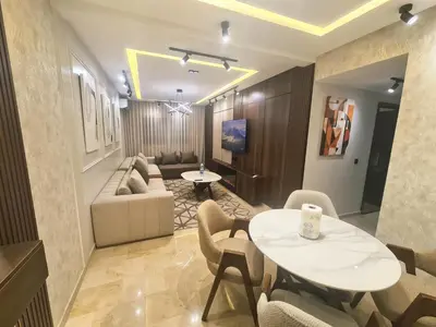 a living room with a table and chairs and a couch at Large luxurious apartment opposite to Hassan 2 Mosqu and FAIR international casablanca , near downtown prohibited arb unmarried couples, Free underground parking for buildings, 3 rooms, 2 bathroom, living room in Casablanca