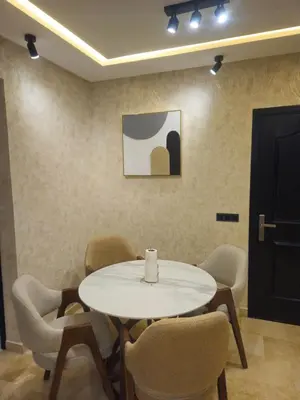 a white table and chairs with a candle on it at Large luxurious apartment opposite to Hassan 2 Mosqu and FAIR international casablanca , near downtown prohibited arb unmarried couples, Free underground parking for buildings, 3 rooms, 2 bathroom, living room in Casablanca