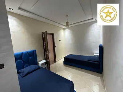 a room with a blue couch and a bed at Appartement noor aéroport casablanca in Deroua