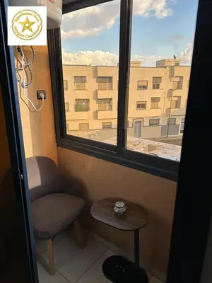 a chair and a table in a room with a window at Appartement noor aéroport casablanca in Deroua
