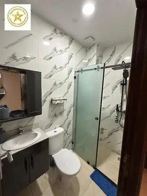 a bathroom with a shower and a toilet and a sink at Appartement noor aéroport casablanca in Deroua