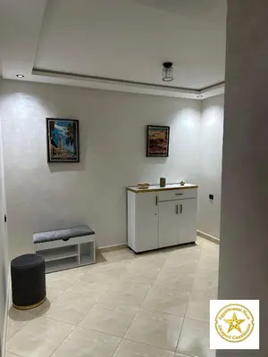 a room with a table and a bench on a wall at Appartement noor aéroport casablanca in Deroua