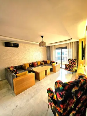 a living room with a couch and a table at Appartement De Standing - Face à La Plage -piscine in Mohammedia