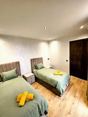a bedroom with two beds with yellow towels on them at Appartement De Standing - Face à La Plage -piscine in Mohammedia