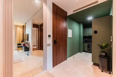 a hallway with green walls and a wooden door at New Architect & Design Studio - CFC & Maarif in Casablanca