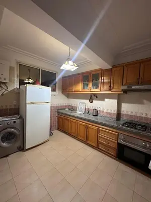 a kitchen with a white refrigerator and wooden cabinets at La Gironde, Families & Friends stay in comfort in Casablanca