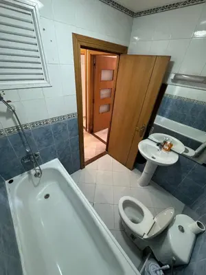 a bathroom with a tub and a toilet and a sink at Apartment near the soccer fields in Rabat