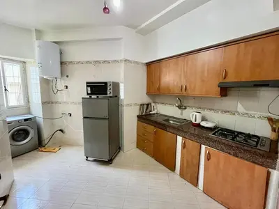 a kitchen with a refrigerator and a microwave in it at Apartment near the soccer fields in Rabat
