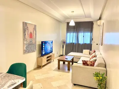 a living room with a couch and a tv at Apartment near the soccer fields in Rabat