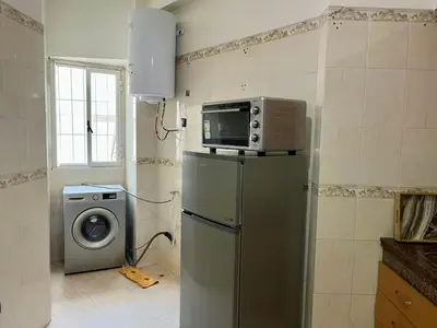 a kitchen with a microwave on top of a refrigerator at Apartment near the soccer fields in Rabat