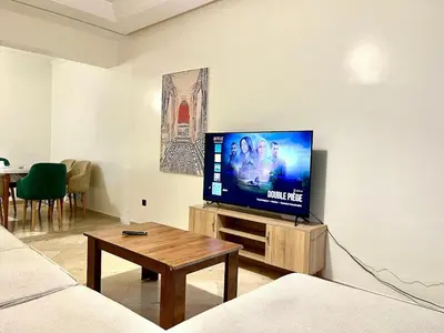 a living room with a flat screen tv on a wall at Apartment near the soccer fields in Rabat