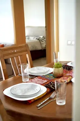 a table with plates and glasses on top of it at appartement with piscine & jardins - Détente à Bouznika, Rabat in Bouznika