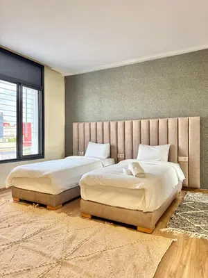a bedroom with two beds and a large window at Villa 1 prestige with Pool & Private Guests Suites in Sidi Yahia az Zaʼer