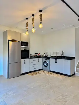 a large kitchen with white cabinets and a refrigerator at Villa 1 prestige with Pool & Private Guests Suites in Sidi Yahia az Zaʼer