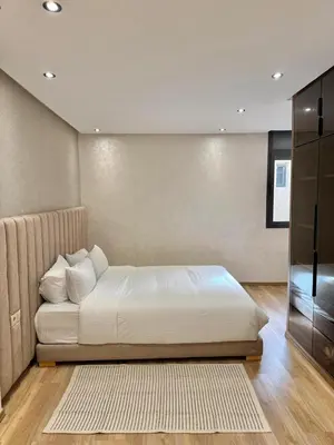 a bedroom with a white bed and a television at Villa 2 Évasion Urbaine, 3 Chambres, à 20 min de Rabat in Sidi Yahia az Zaʼer