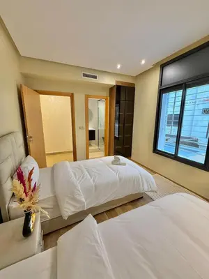 a bedroom with two beds and a window at Villa 2 Évasion Urbaine, 3 Chambres, à 20 min de Rabat in Sidi Yahia az Zaʼer
