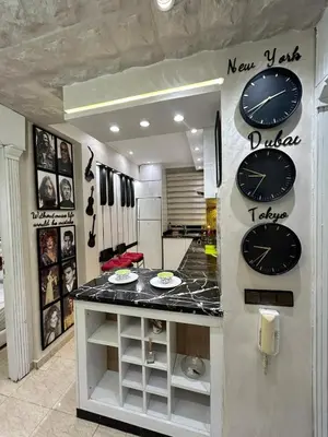 a kitchen with a counter with clocks on the wall at Sympa appartement corniche in Casablanca