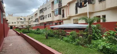 a courtyard of an apartment building with a table and umbrella at CAN Comfort 2 Bedrooms in Temara