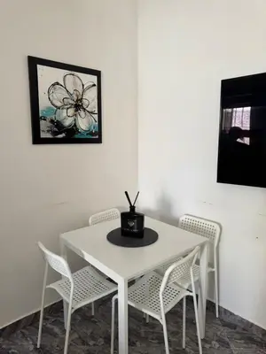 a white table and chairs in a room at Apartment dar bouazza in Dar Bouazza