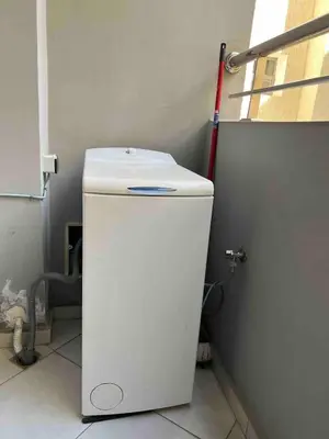 a small white refrigerator in a room with a red hose at Appartment Maarif proche toutes commoditées in Casablanca