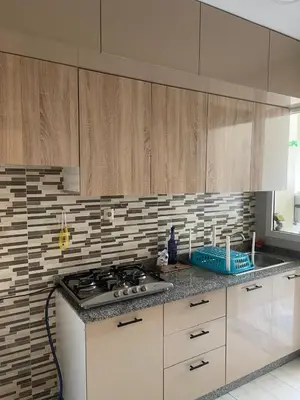 a kitchen with wooden cabinets and a stove top oven at Appartement andalous bouskoura in Bouskoura