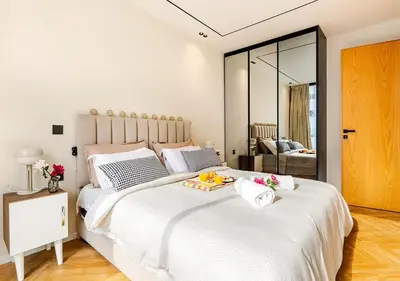 a bedroom with a large white bed with a tray of fruit on it at Dynasty Estate - Appartement chic et central Yacoub Al Mansour in Casablanca