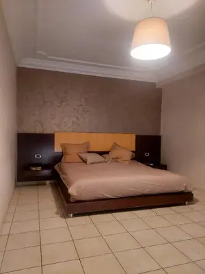 a bedroom with a large bed with a headboard at Appartement Familial Casablanca in Casablanca