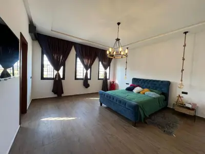 a bedroom with a blue couch in a room with windows at Ferme villa in Skhirat